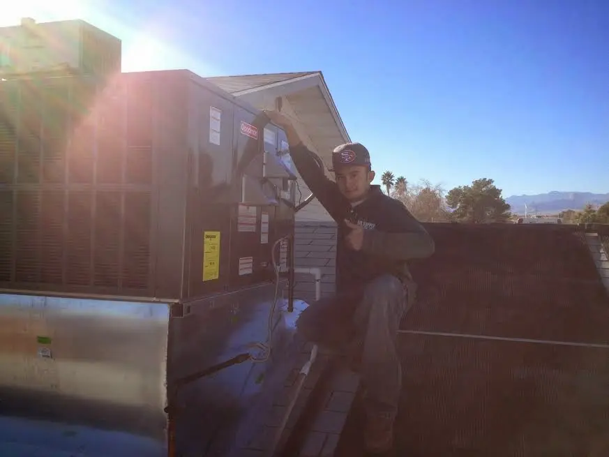 HVAC technician performing Boiler Repair on a rooftop unit in Glenmont